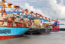 blue and red cargo ship on dock during daytime