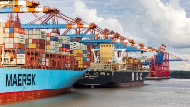 blue and red cargo ship on dock during daytime