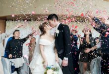 man in black suit kissing woman in white wedding dress