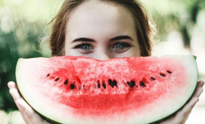 woman holding sliced watermelon