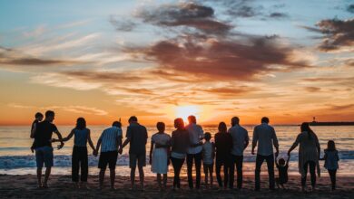 people standing on shore during golden hour