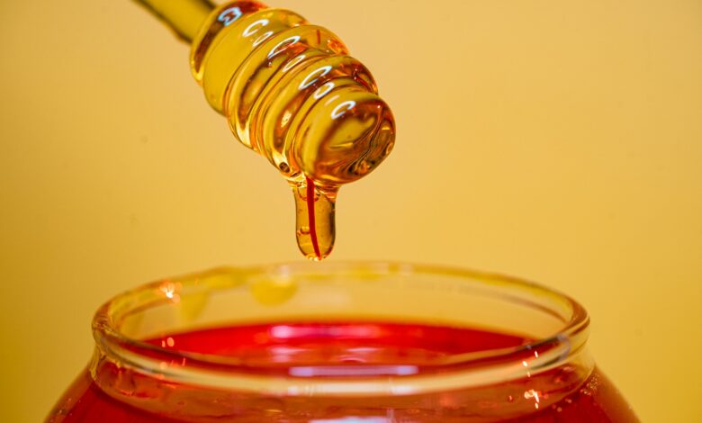 clear glass bottle pouring red liquid on clear drinking glass